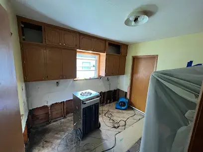 Dehumidifier and air mover drying a kitchen after the lower cabinets and wall bottoms were removed