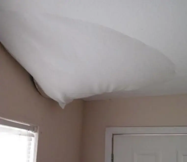 Ceiling drywall sagging in a bubble from water trapped above it